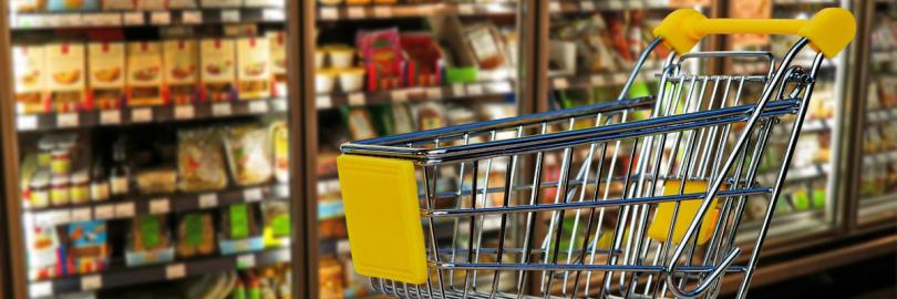 Leerer Einkaufswagen vor Supermarkt-Kühlschränken