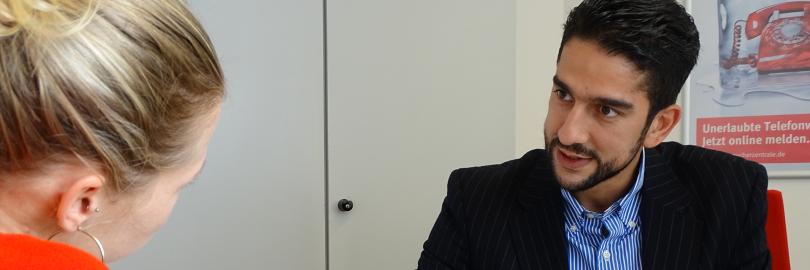 Mann berät eine Frau an einem Tisch