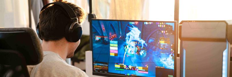 Ein Junge spiel ein Online-Game und hat Headphones auf.