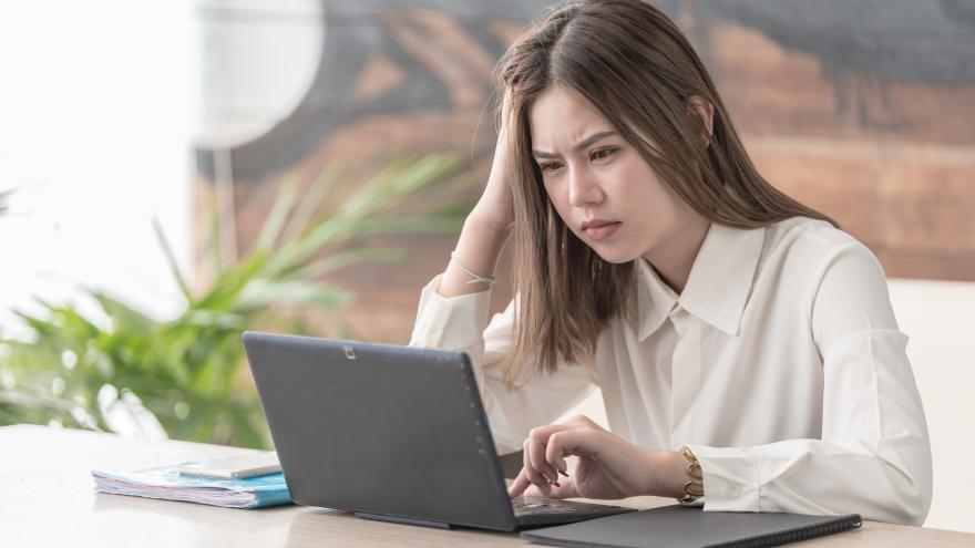 Frau sitzt verärgert vor dem Laptop