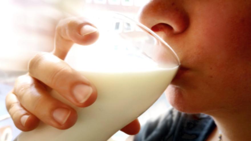 Frau trinkt aus einem Glas Milch