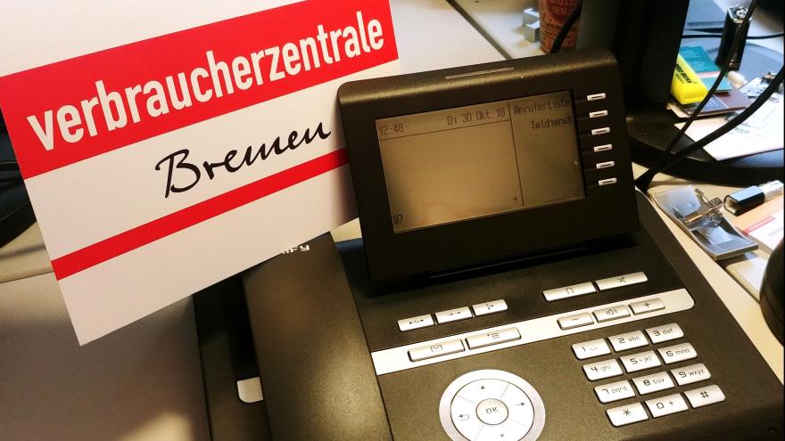 Telefon mit Schild Verbraucherzentrale Bremen
