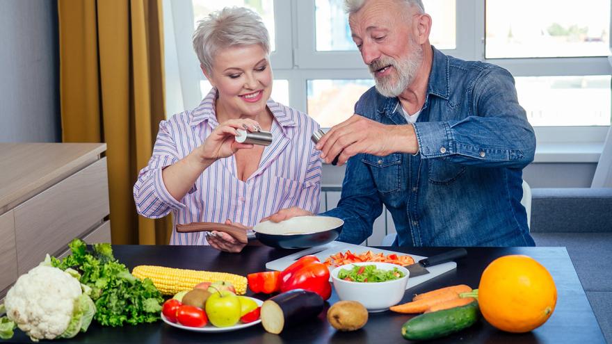 Ein Paar salzt das Essen am Tisch