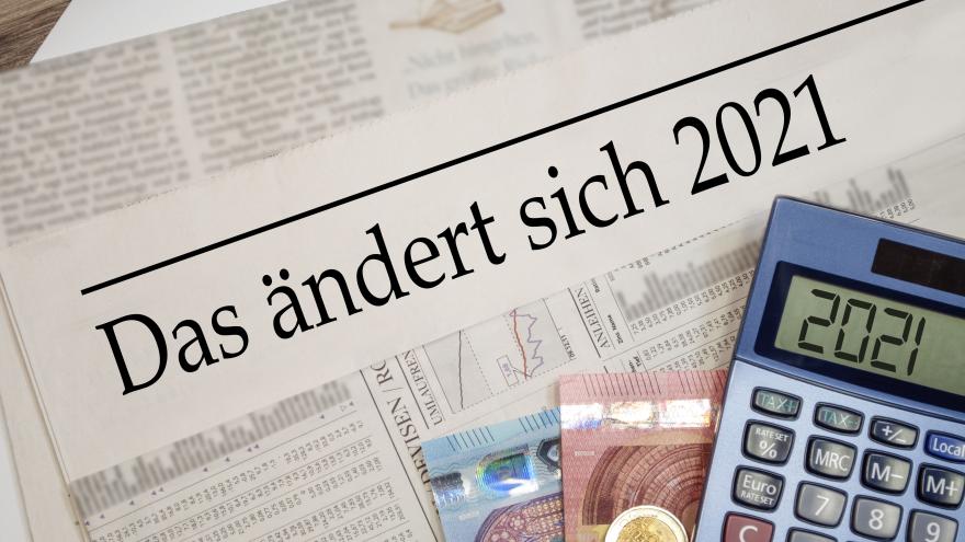 Eine Zeitung aus dem Jahr 2021 mit Taschenrechner und Geldscheinen darauf.