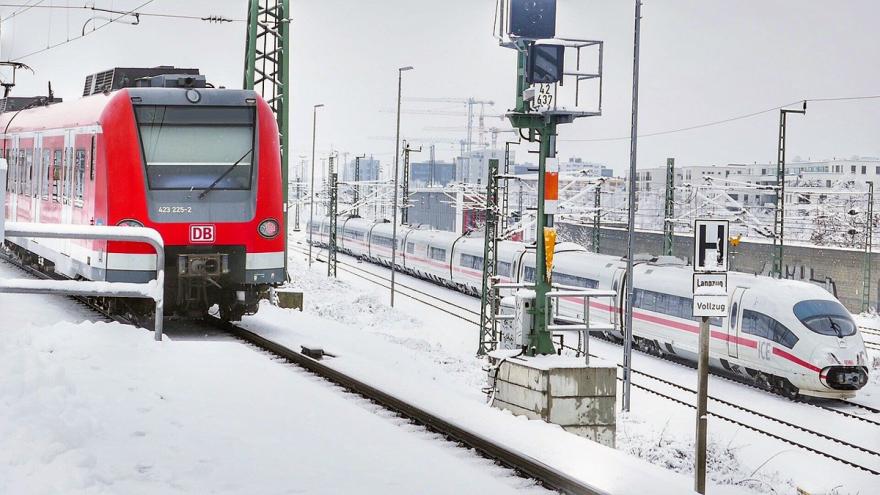 Regionalzug und ICE auf Bahngleisen im Schnee