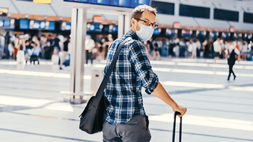 Mann im Flughafen mit Rollkoffer