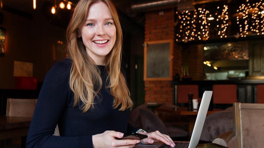Frau am Laptop mit Handy