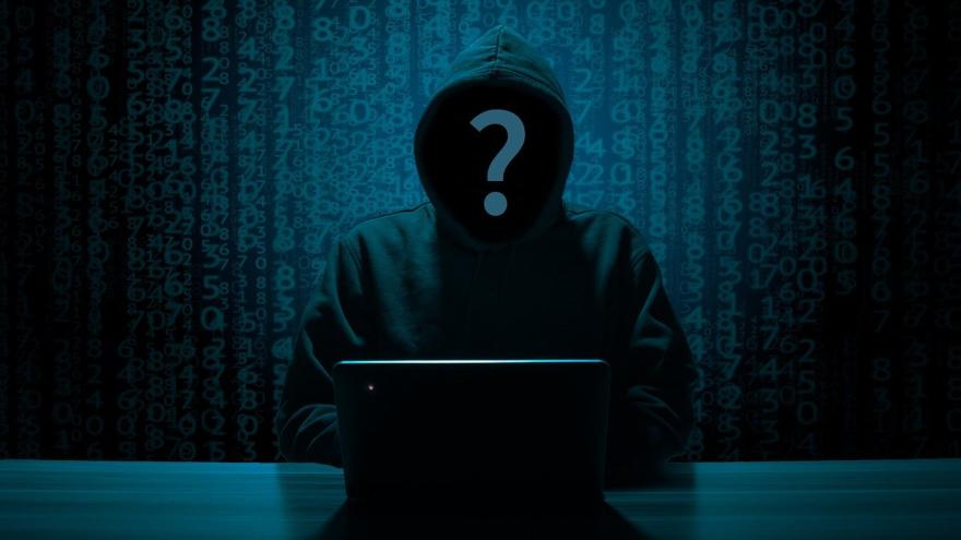 Cybercrime Mensch mit Kapuze vor Laptop