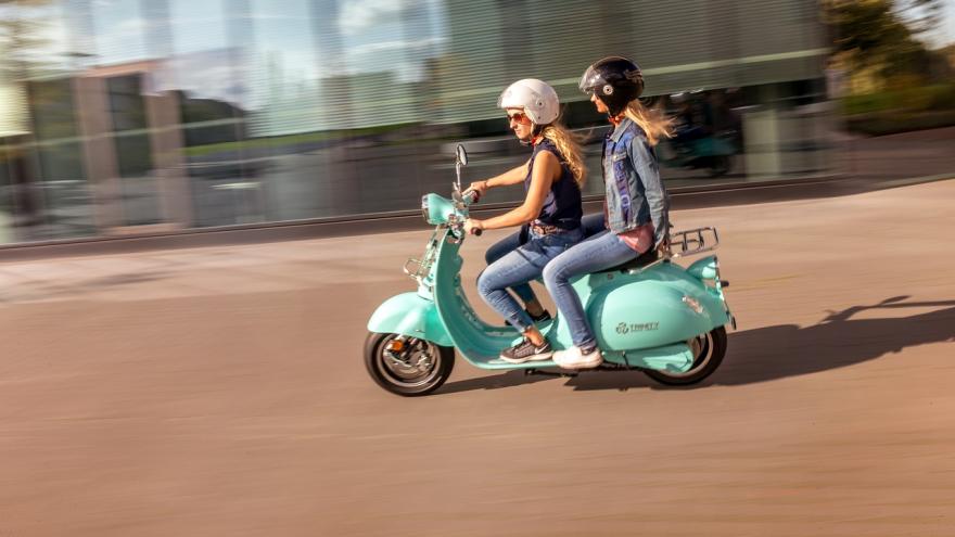 Zwei Frauen mit Helm auf einem E-Roller E-Scooter