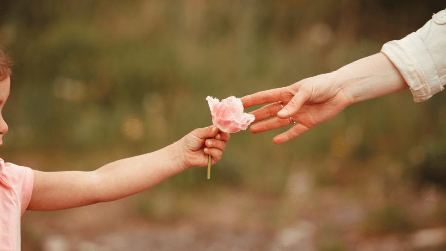 Kinder und Erwachsenenhände zu sehen, Kind gibt Erwachsene Blume