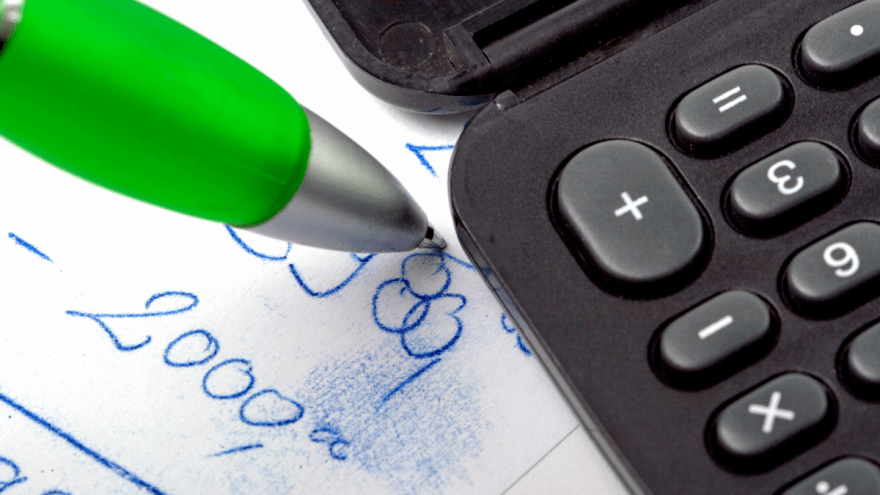 Taschenrechner, Stift und ein Zettel mit einer Rechnung