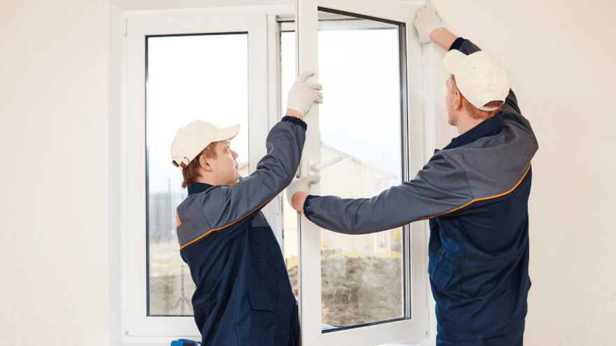 Zwei Handwerker bauen ein neues Fenster ein