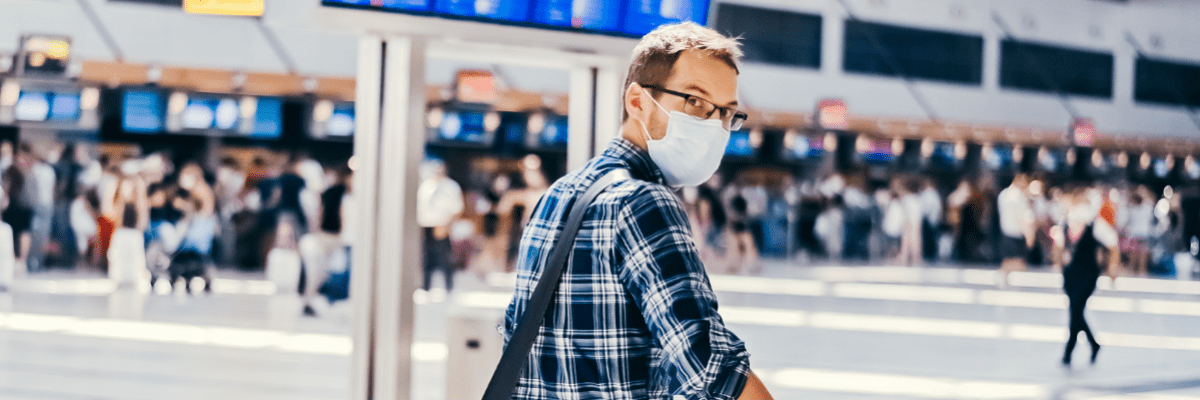 Mann am Flughafen mit Maske