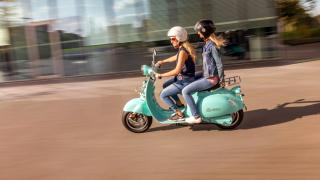 Zwei Frauen mit Helm auf einem E-Roller E-Scooter