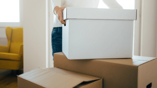 Umzugskarton wird auf andere Kartons gestellt