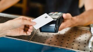 Bankkarte wird auf ein Lesegerät gehalten