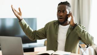 Schmuckbild: Mann vor Laptop, der aufgebracht telefoniert