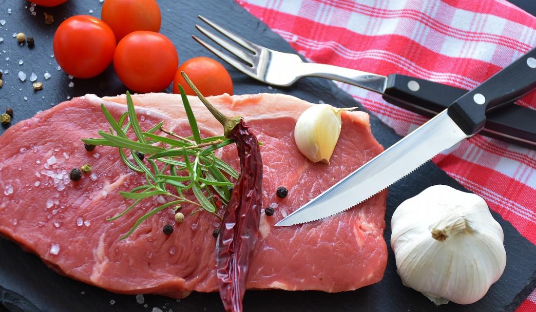 Rohes Steak mit Gewürzen, Knoblauch und Tomaten dekoriert