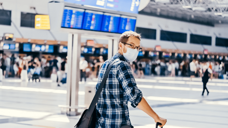 Mann am Flughafen mit Maske